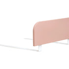 Das minimalistische rosafarbene Kopfteil mit abgerundeten Kanten und weißen Metallfüßen passt perfekt zum KraftKids Bettschutzgitter Rausallschutz in Pastellrosa - ein stilvoller, sicherer und verstellbarer Schutz für Kinderbetten.