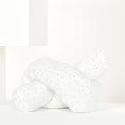 Die Wickeltischrolle Musselin goldene Punkte auf Weiß der KraftKids GmbH ruht auf einer minimalistischen weißen Fläche inmitten eines geometrischen Hintergrunds.