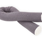 Die KraftKids Wickeltischumrandung Musselin goldene Punkte auf Grau ist eine lange, flexible Bettschlange mit grauem Bezug und goldenen Punkten sowie weißen Enden - perfekt als Bettrolle oder Kantenschutz-Wickelkommode für Ihr Kinderzimmer.