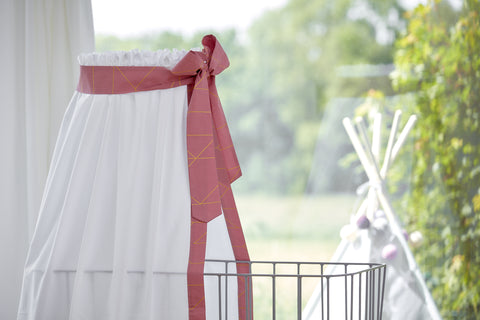 Letto a baldacchino con linee dorate su fondo rosa