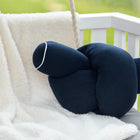 Ein KraftKids Wickeltischumrandung Musselin dunkelblau mit weißer Paspelierung ruht auf einer beigen Fleecedecke, die über einer Bank mit weißen Latten drapiert ist, draußen im Tageslicht.