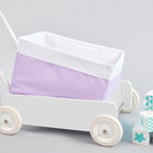 Ein weißer Spielzeugwagen mit dem KraftKids Körbchen Uniweiss weiße Punkte auf Lila sitzt neben blauen und weißen Deko-Blöcken und bietet stilvolle Aufbewahrung im Kinderzimmer vor einem hellgrauen Hintergrund.