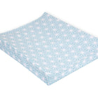 Der KraftKids Bezug für Keilwickelauflage in pastellblau hat ein weißes Rautenmuster, erhabene Ränder und einen Bezug aus 100% Baumwolle, abgebildet auf einer blauen, rechteckigen Wickelauflage vor weißem Hintergrund.