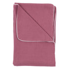 Die KraftKids Babydecke Musselin purpur, eine gefaltete lilafarbene Musselin-Babydecke mit weißem Rand, wird vor einem weißen Hintergrund gezeigt.