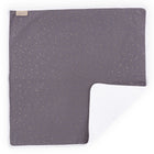 Die KraftKids Wickelunterlage Musselin goldene Punkte auf Grau ist eine quadratische, dunkelgraue Babydecke mit goldenen Punkten und einem weichen, weißen, strukturierten Futter - ideal als Wickelauflage oder Reisewickelunterlage. Eine Ecke offenbart die kuschelige weiße Unterseite.